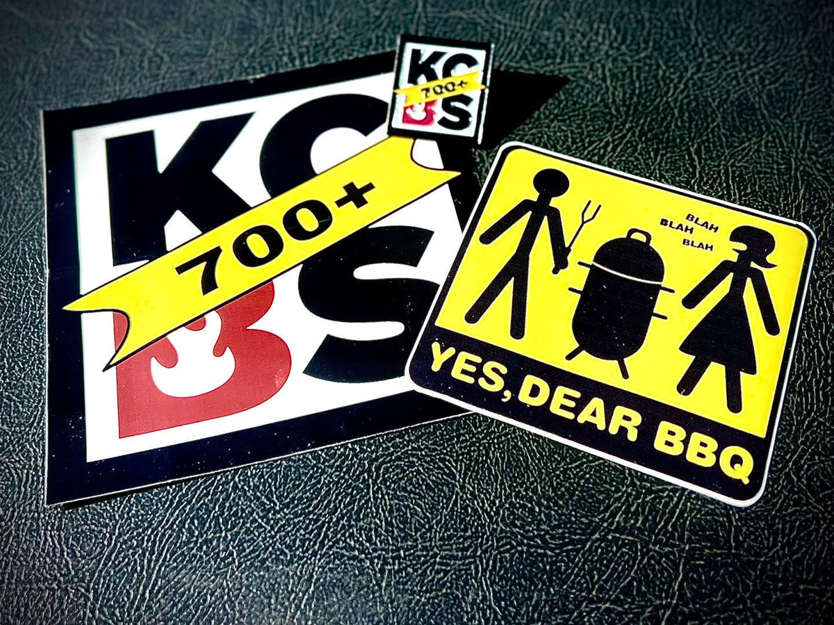 Two KC BBQ stickers and a yes dear bbq logo sticker on black background