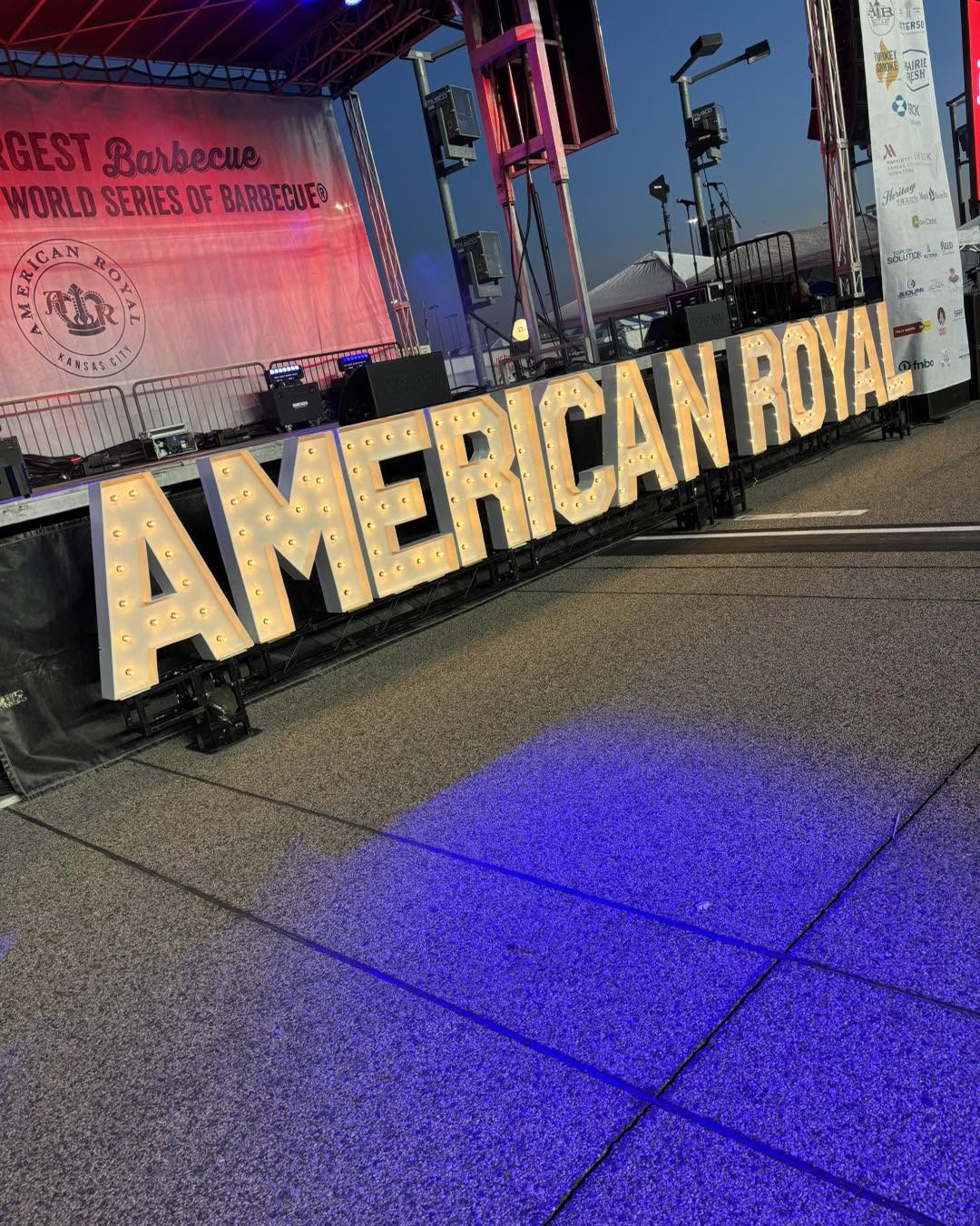 Large illuminated freestanding letters spelling AMERICAN ROYAL