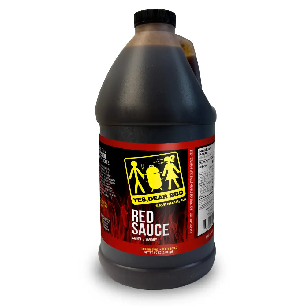 A large plastic jug of Yes, Dear BBQ Red Sauce on a plain white background. The jug is filled with dark red sauce and features a black cap and a red label with yellow and white text.